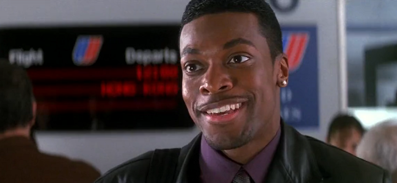 Chris Tucker as Carter smiling in an airport