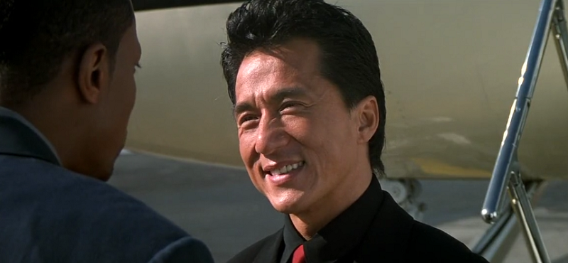 Jackie Chan as Lee smiling at Carter near airplane
