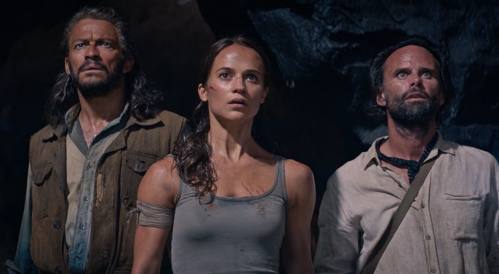 Dominic West, Alicia Vikander, and Walton Goggins in a dark cave