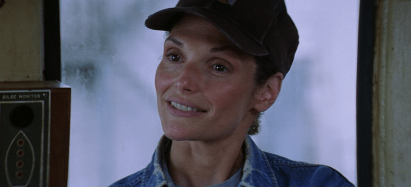 Mary Elizabeth Mastrantonio smiling gently in a hat.