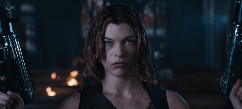 Milla Jovovich as Alice holding two MP5s in a church