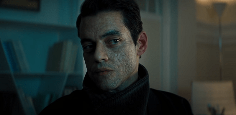 Rami Malek with a scarred face looking sideways