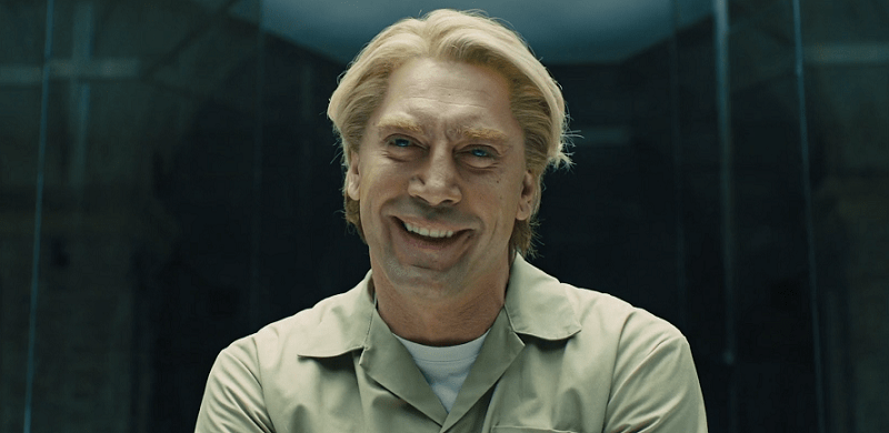 Javier Bardem laughing with blod hair in a glass box