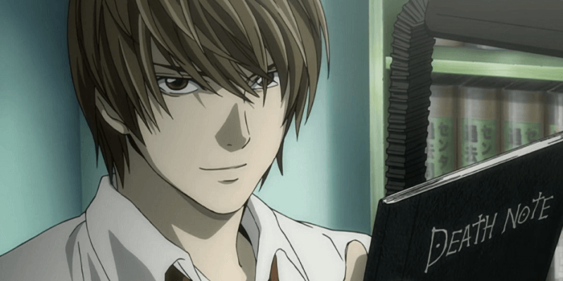 Light Yagami Kira holding the Death Note and smiling