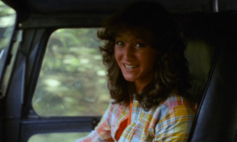 Annie smiling nervously in a colorful shirt in a car.