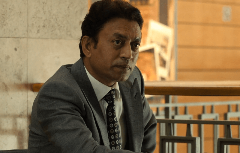 Irrfan Khan sitting with a grey suit on.