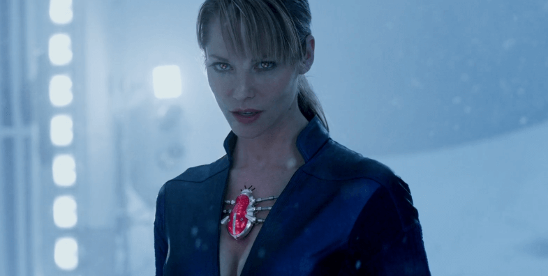 Sienna Guillory as Jill Valentine in blue leather outfit with glowing eyes in the snow.