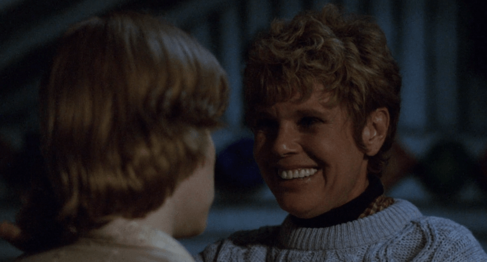Mrs Voorhees smiling at Alice in a dark cabin in Friday the 13th.