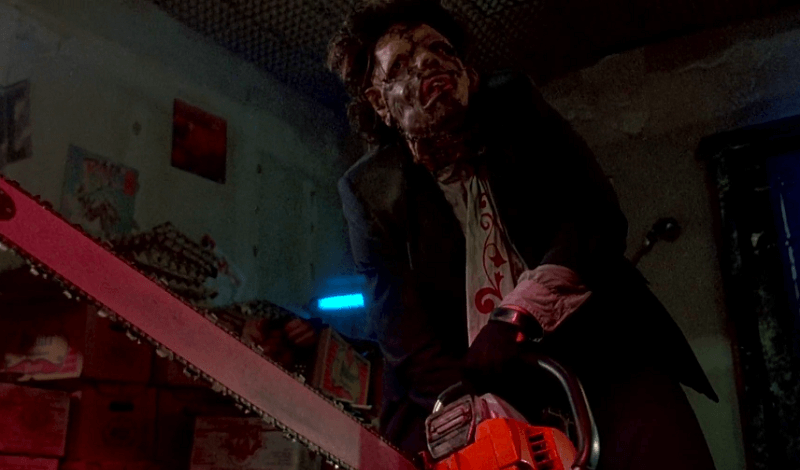 Leatherface holding a chainsaw with an intense stare.