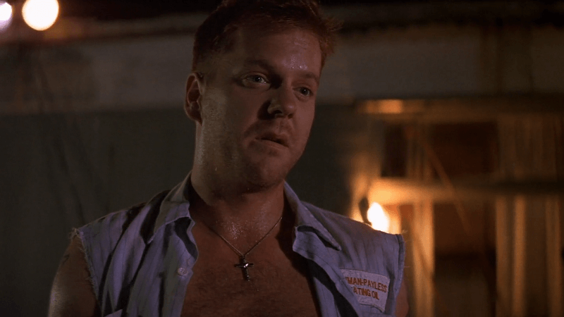 Kiefer Sutherland as Freddie Lee Cobb wearing a cross and a torn up shirt.
