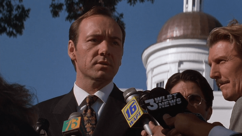 Kevin Spacey with a bunch of reporters surrounding him.
