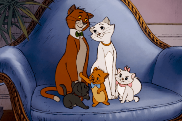 Thomas O'Malley looking lovingly at Duchess and her three kittens on a blue royal sofa.
