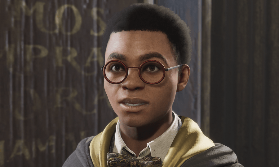Arthur Plummly wearing the Hufflepuff cloak and bow tie while smiling with round spectacles.