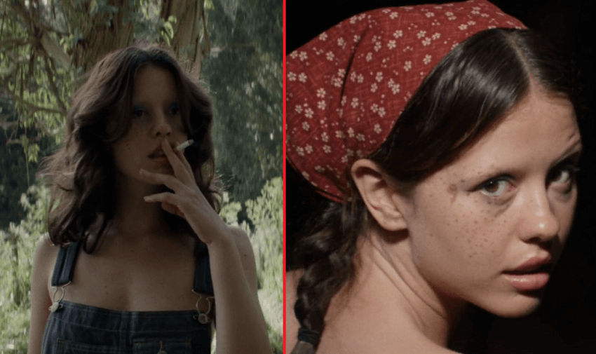 Mia Goth as Maxine smoking a cigarette and looking over her shoulder with a red towel on her head.