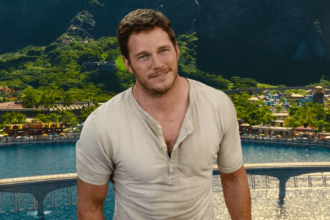 Chris Pratt looking up with a huge smile wearing a beige shirt in Jurassic World.