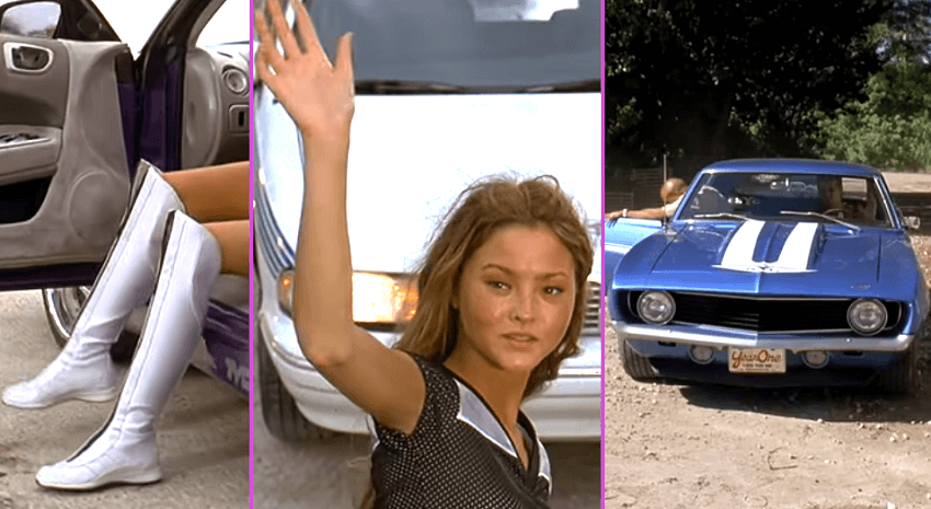Devon Aoki with 2 white boots and waving next to a blue car.