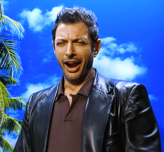 Ian Malcolm jawning against a blue sky and palm tree in a leather jacket.