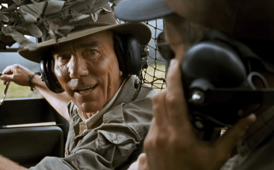 Pete Postlethwaite as Roland Tembo in jungle gear driving a car in The Lost World.
