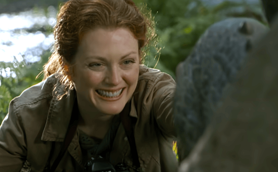 Julianne Moore as Sarah Harding touching a dragon and smiling.